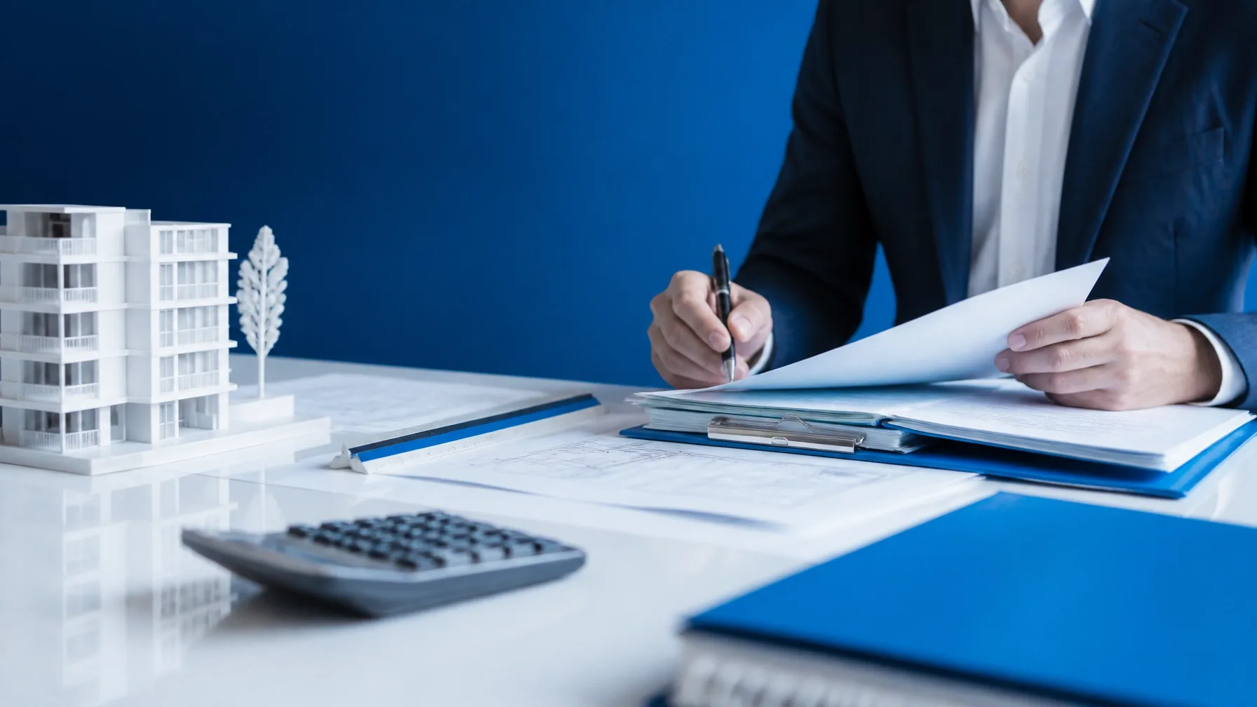 Perito valuador certificado revisando planos y documentación técnica de un inmueble